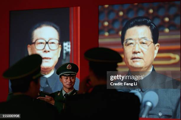 The paramilitary policemen pose in front of the portraits of China's President Hu Jintao and former President Jiang Zeming as visiting an exhibition...