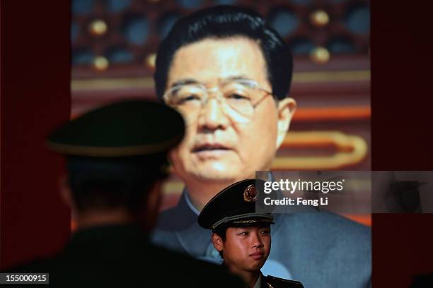 Paramilitary policeman passes the portrait of China's President Hu Jintao as visiting an exhibition entitled "Scientific Development and Splendid...