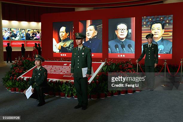 The paramilitary policemen pose for photo in front of the portraits of China's President Hu Jintao and former President Jiang Zeming as visiting an...