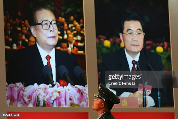 Paramilitary policeman passes the portraits of China's President Hu Jintao and former President Jiang Zeming as visiting an exhibition entitled...