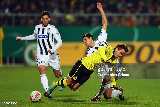 Mario Goetze of Dortmund is challenged by Andreas Hofmann of Aalen during the second round match of the DFB Cup between VfR Aalen and Borussia...