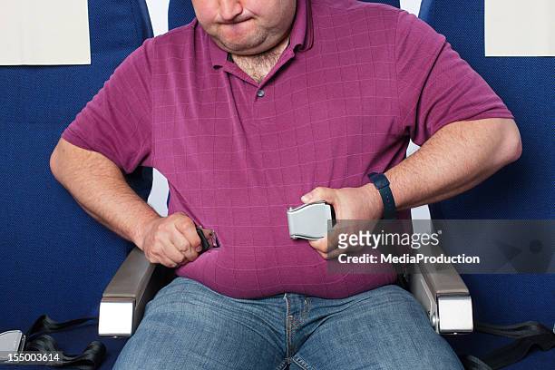 übergewichtige mann in ein flugzeug - full figure stock-fotos und bilder