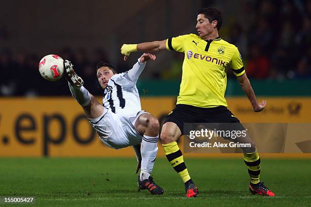 Robert Lewandowski of Dortmund is challenged by Tim Kister of Aalen during the second round match of the DFB Cup between VfR Aalen and Borussia...
