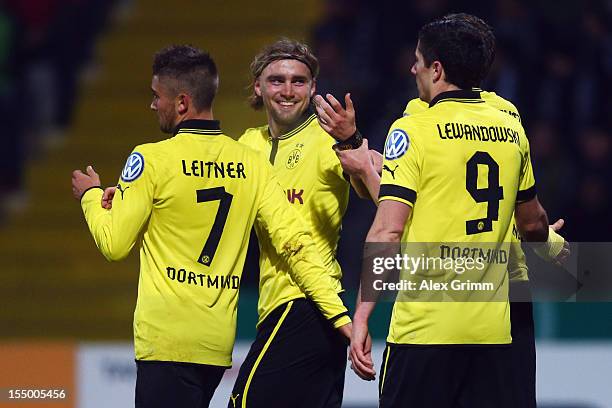 Marcel Schmelzer celebrates his team's second goal with team mates Moritz Leitner and Robert Lewandowski during the second round match of the DFB Cup...