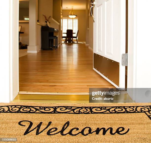 "welcome" mat in front of white open door - welcome mat stock pictures, royalty-free photos & images