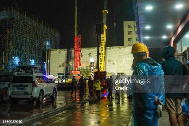 Rescuers work at a school gym after the roof of the building collapsed in Qiqihar, in China's northeastern Heilongjiang province early on July 24,...