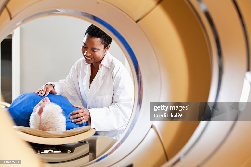 Radiologist preparing patient for PET-CT scanner.