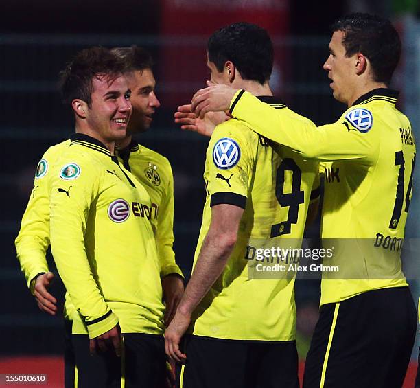 Mario Goetze of Dortmund celebrates his team's third goal with team mates Moritz Leitner, Robert Lewandowski and Ivan Perisic during the second round...