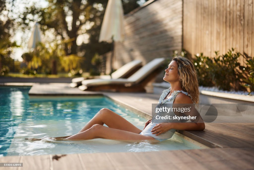 Smiling woman enjoying in summer day at the pool.