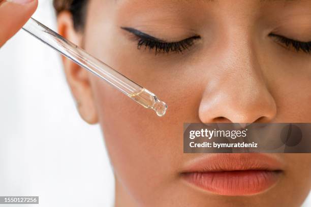 woman applying essential oil - serum stock pictures, royalty-free photos & images