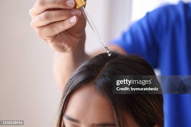 handhaltende pipette mit serum - argan oil stock-fotos und bilder