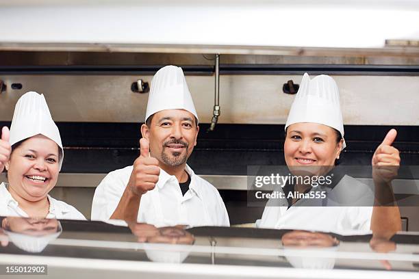 portrait of three happy smiling chefs inside the restaurant kitchen - mexican restaurant stock pictures, royalty-free photos & images