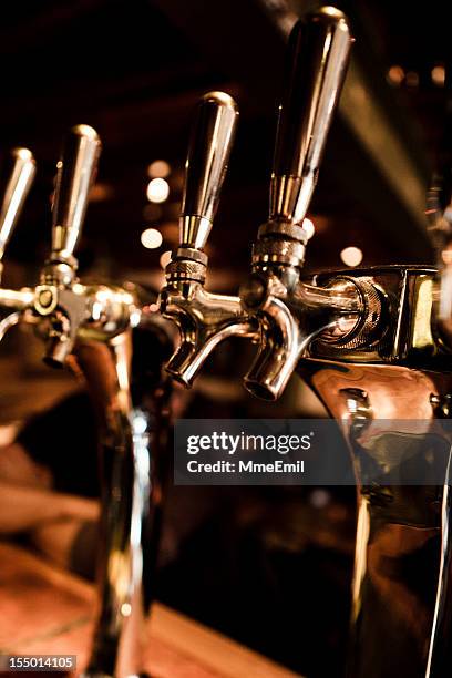 beer taps in a bar on table top - beer tap stockfoto's en -beelden