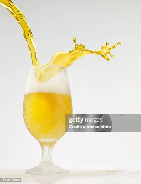 splashing - beer pour in glass - beer splashing stock pictures, royalty-free photos & images