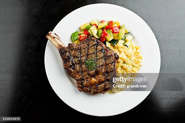 rib-eye-steak mit makkaroni und käse - t bone steak on the grill stock-fotos und bilder