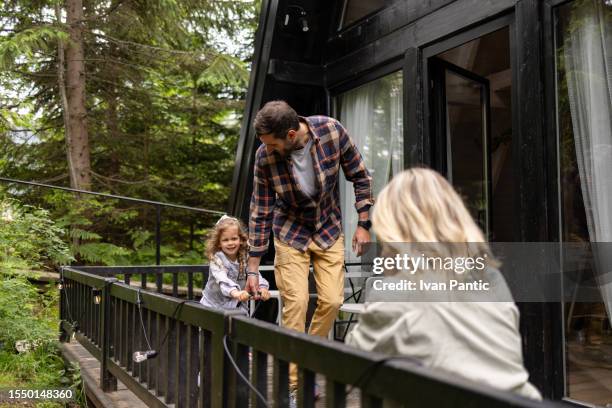 carefree father and daughter having fun on a terrace. - summer cottage stock pictures, royalty-free photos & images