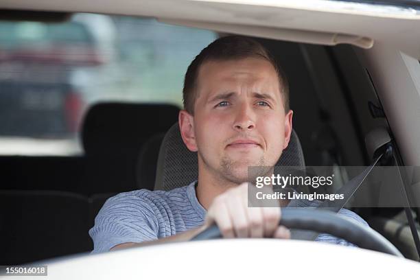 man driving his car and squinting - drivers seat stock pictures, royalty-free photos & images