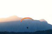 Man riding a paramotor Watch the sunset in Vang Vieng , Loas, nestled among towering mountains and forested hills.
