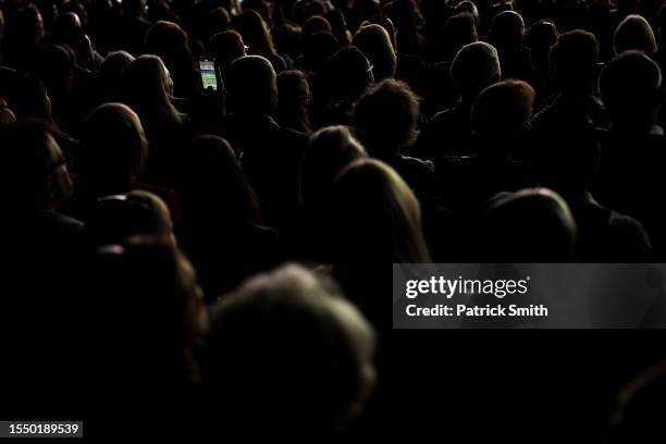 Fan uses an iPhone to record Carlos Alcaraz of Spain playing in the Men's Singles Final against Novak Djokovic of Serbia on day fourteen of The...