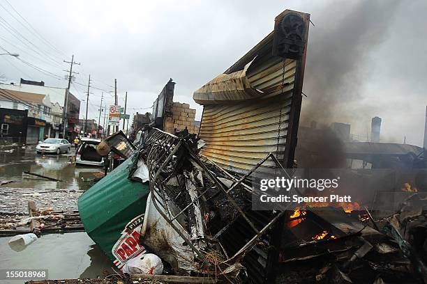 Fire burns near destroyed homes and businesses following Hurricane Sandy on October 30, 2012 in the Rockaway section of the Queens borough of New...