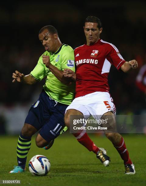 Gabriel Agbonlahor of Aston Villa challenges Joe Devera of Swindon Town during the Capital One Cup Fourth Round match between Swindon Town and Aston...