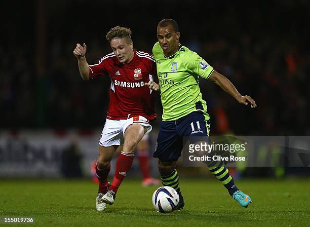 Simon Ferry of Swindon Town challenges Gabriel Agbonlahor of Aston Villa during the Capital One Cup Fourth Round match between Swindon Town and Aston...