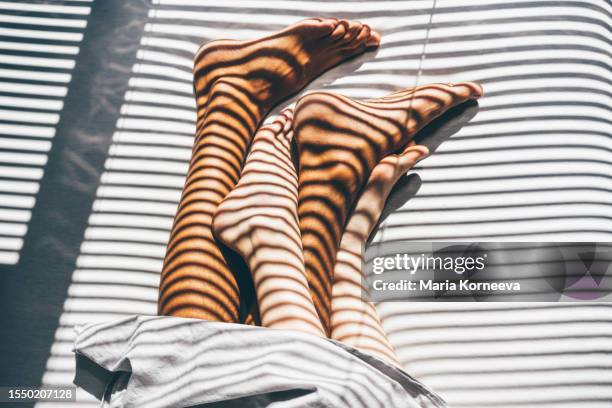 interracial couple sleeping on the bed. close up legs. - verlangen verhalten und emotionen stock-fotos und bilder
