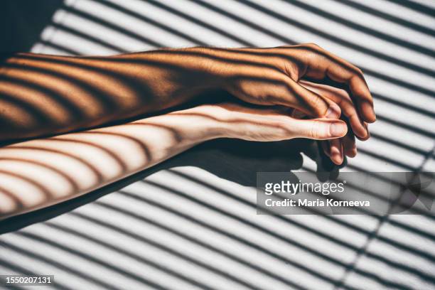 interracial couple holding hands on the bed. - desire foto e immagini stock