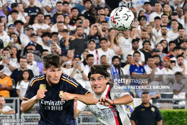 Real Madrid's Spaniard defender Francisco Garcia fights for the ball with AC Milan's Argentine midfielder Luka Romero during the friendly football...