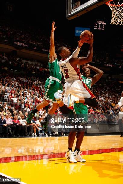 Dwyane Wade of the Miami Heat shoots against Courtney Lee and Brandon Bass of the Boston Celtics during a game on October 30, 2012 at American...