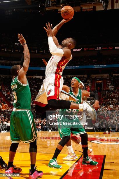 Dwyane Wade of the Miami Heat shoots against Rajon Rondo of the Boston Celtics during the NBA game on October 30, 2012 at American Airlines Arena in...