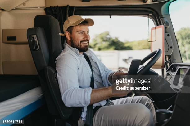 mid adult man using digital tablet - drivers seat stock pictures, royalty-free photos & images