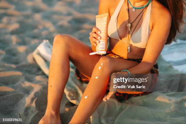 putting on some sun protection cream - putting sunscreen stock pictures, royalty-free photos & images