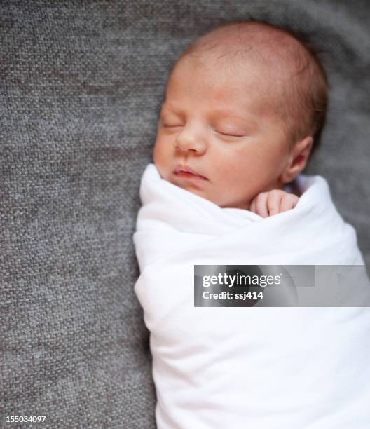 newborn baby on gray blanket - babydeken stockfoto's en -beelden