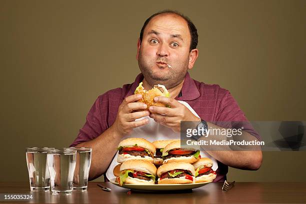man eating many burgers - large group of objects stock pictures, royalty-free photos & images