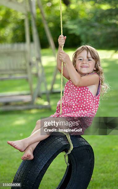 cute young girl on a tire swing - tire swing stock pictures, royalty-free photos & images