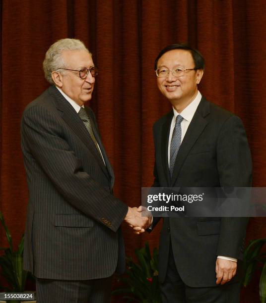 Arab League peace envoy for Syria Lakhdar Brahimi shakes hands with Chinese Foreign Minister Yang Jiechi prior to their meeting at the Ministry of...