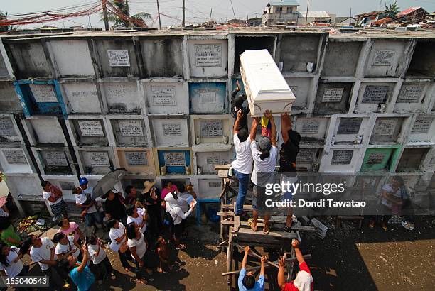 Coffin is placed on a tombstone during a funeral at the Navotas public cemetery on October 31, 2011 in Manila, Philippines. The 'Day of the Dead ,...