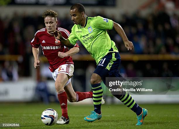 Gabriel Agbonlahor of Aston Villa is challenged by Simon Ferry of Swindon Town during the Capital One Cup Fourth Round match between Swindon Town and...