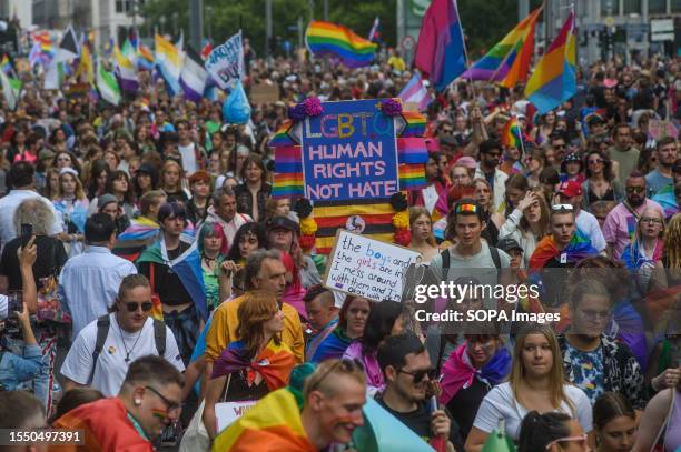 People march with pride flags and placards during the pride parade. Berlin Christopher Street Day or Berlin Pride Parade is an annual demonstration...