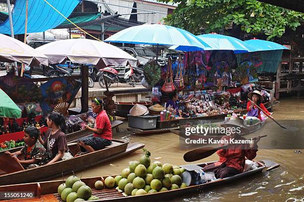 Female Thai vendor sells coconuts on her boat while circulating on the canal in floating market on October 13 in Damnoen Saduak, Thailand. Damnoen...