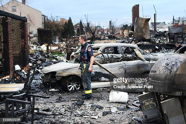 Firefighter stands among the remains of homes burned down in the Rockaway neighborhood during Hurricane Sandy on October 31, 2012 in the Queens...