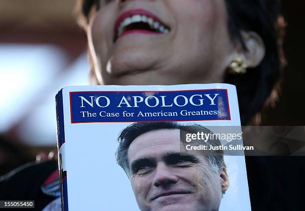 Supporter of Republican presidential candidate, former Massachusetts Gov. Mitt Romney holds his book "No Apology" during campaign rally at Tampa...