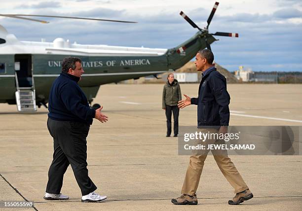 President Barack Obama is greeted by New Jersey Governor Chris Christie upon arriving in Atlantic City, New Jersey, on October 31, 2012 to visit...