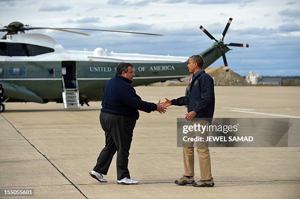 President Barack Obama is greeted by New Jersey Governor Chris Christie upon arriving in Atlantic City, New Jersey, on October 31, 2012 to visit...