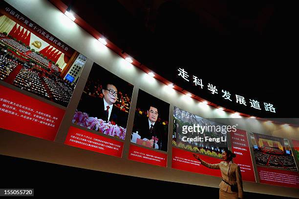Guide introduces the portraits of China's President Hu Jintao and former President Jiang Zeming as Chinese people visiting an exhibition entitled...