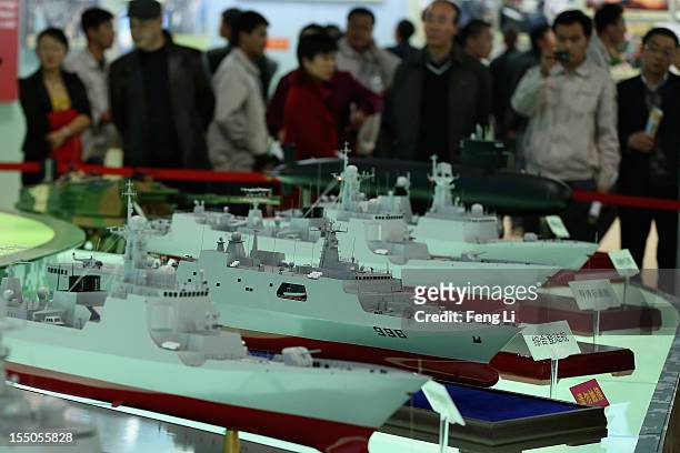 Chinese people look at warship models as visiting an exhibition entitled "Scientific Development and Splendid Achievements" before the18th National...