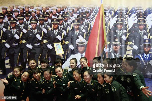Female soldiers pose for photos as visiting an exhibition entitled "Scientific Development and Splendid Achievements" before the18th National...