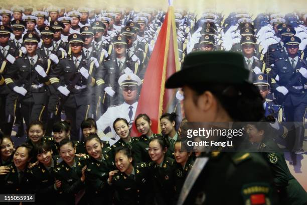 Female soldiers pose for photos as visiting an exhibition entitled "Scientific Development and Splendid Achievements" before the18th National...
