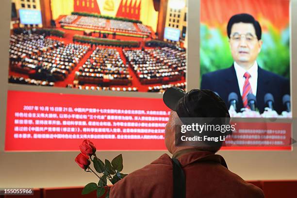 Man passes the picture of China's President Hu Jintao as visiting an exhibition entitled "Scientific Development and Splendid Achievements" before...